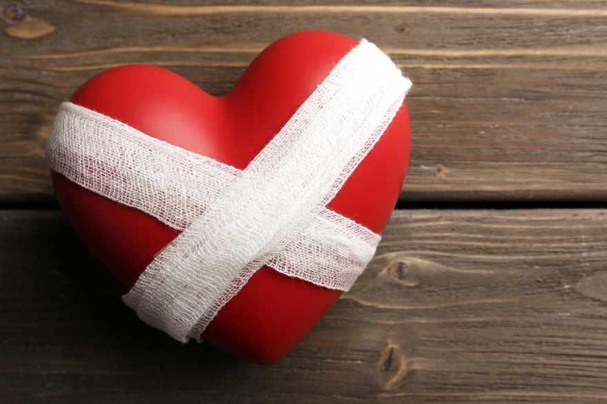 Bandaged heart on wooden background